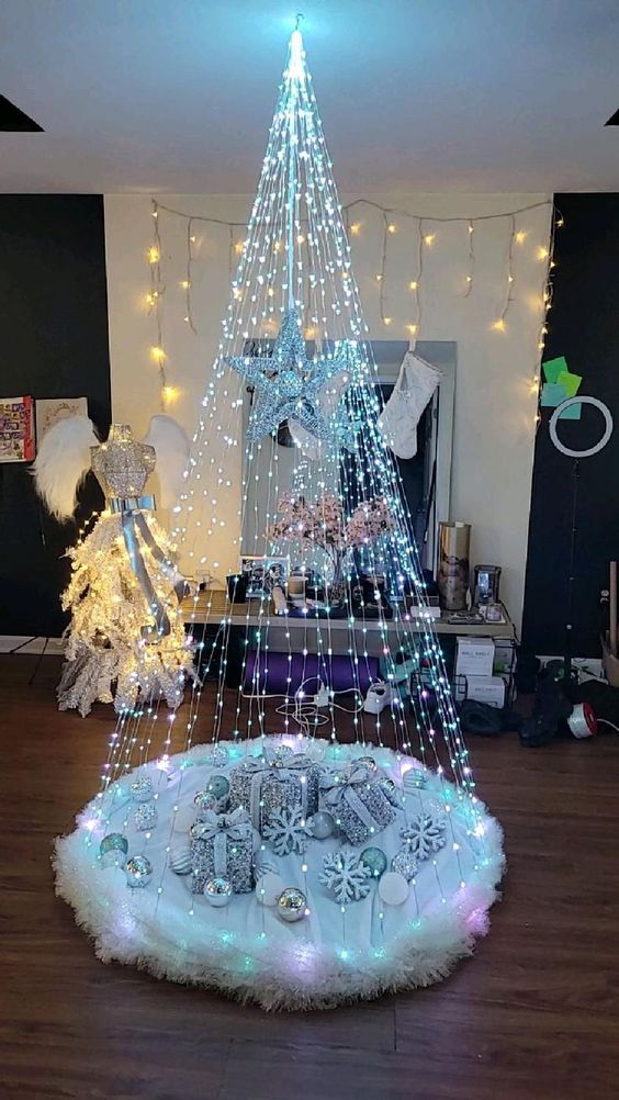 sapin de lumières suspendu sus tapis de cadeaux 